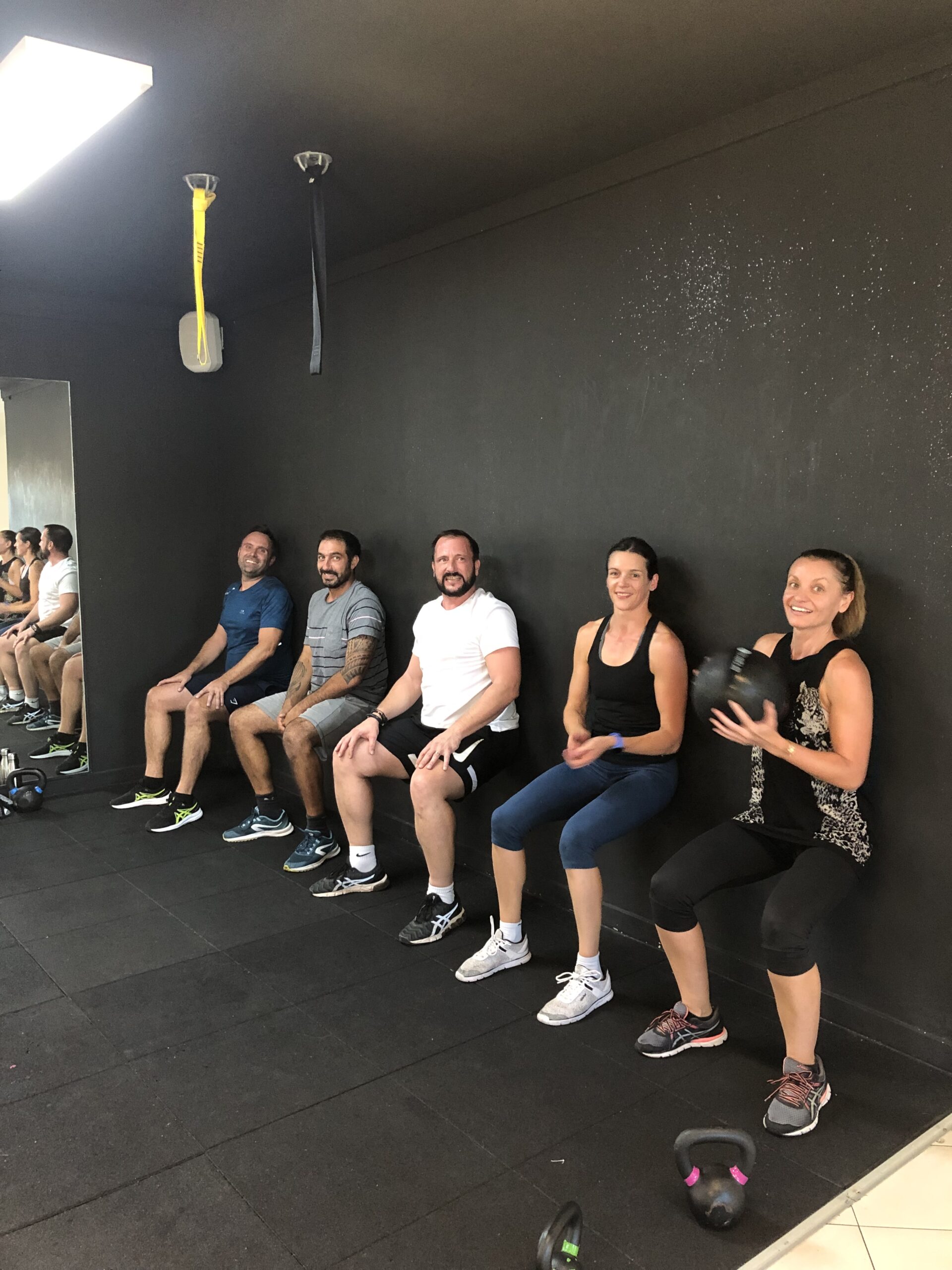 Cours en small group training à La Seyne : exercice gainage en chaise à La Seyne